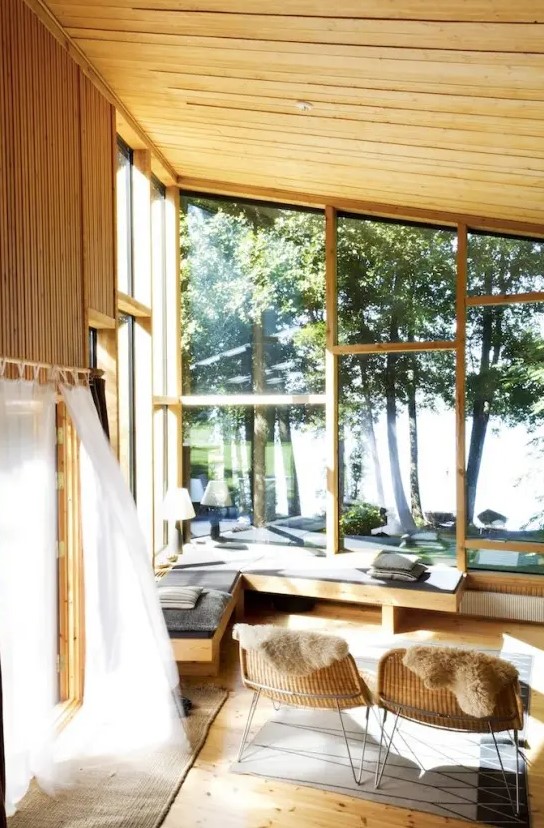 a beautiful and natural-looking sunroom with a natural feel, with much sunshine, an upholstered corner bench, wicker furniture and printed textiles