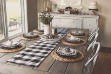 a cozy traditional farmhouse dining room with checked textiles, a wooden table, metal chairs and a buffet