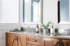 a large farmhouse bathroom with a large stained wooden vanity, mirrors and potted plants