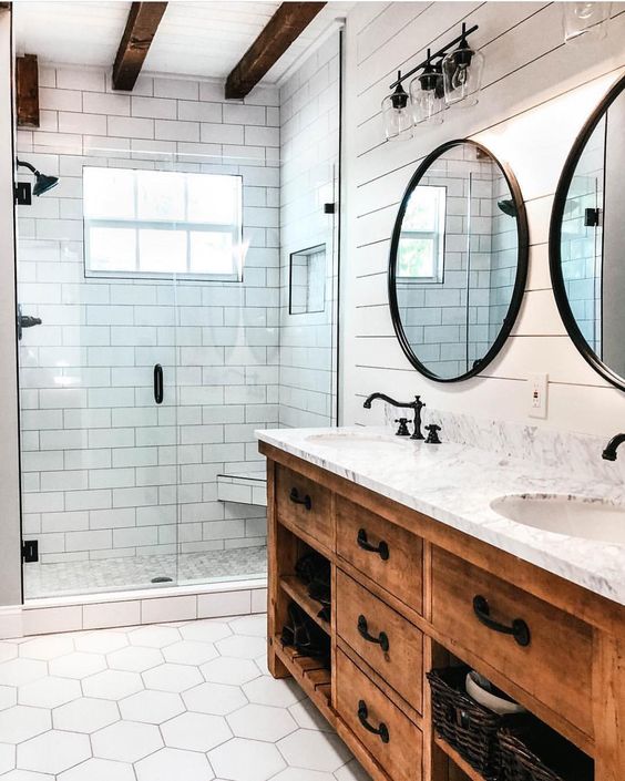 a modern farmhouse bathroom with a staiend vanity, hex tiles on the floor and dark wooden beams