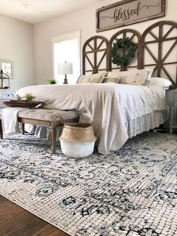 a modern farmhouse bedroom with a catchy wooden headboard, a vintage bech and baskets for storage