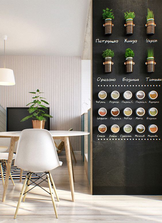a neutral kitchen with a chalkboard wall with magnet spice holders and mini pots and everything marked on the wall