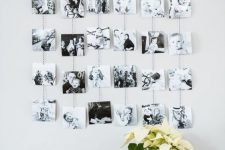 a photo display with a wooden rail and black and white photos on yarn hanging down is a lovely idea