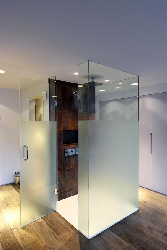 a shower space with glass walls and a door done frosted and a single tiled wall with fixtures is catchy and lovely