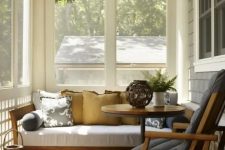 a tiny mid-century modern sunroom with some comfortable furniture,wicker lamps and potted greenery