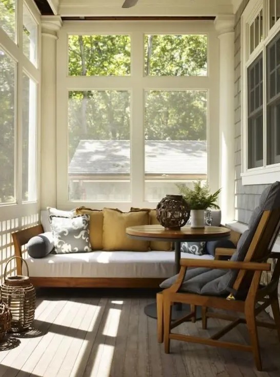 a tiny mid-century modern sunroom with some comfortable furniture,wicker lamps and potted greenery