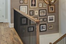 a vintage-inspired gallery wall with photos in mismatching frames over the staircase is a cozy decor idea