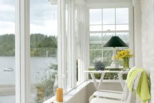 a welcoming tiny sunroom with some foldable chairs and a table, blooms, lamps and candles