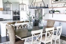 an airy modern farmhouse dining area with a wooden table, wicker and wooden chairs and open shelving