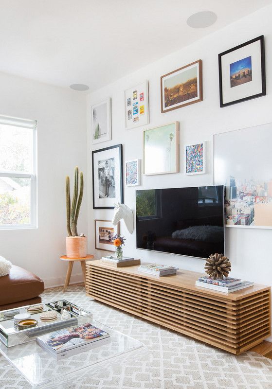 an eclectic gallery wall with bright photos and mismatching frames all over the wall is cool and bold