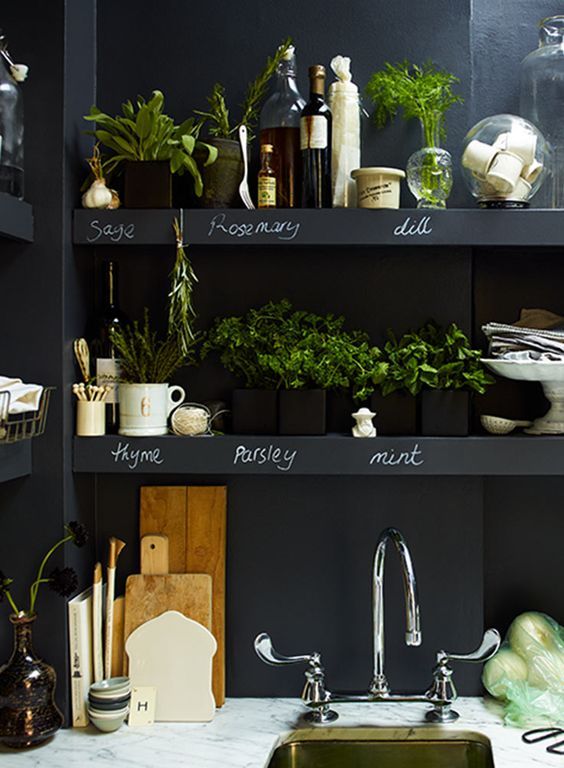 chalkboard walls with built-in open shelves over the whole kitchen are great for any kinds of marks, messages and other stuff