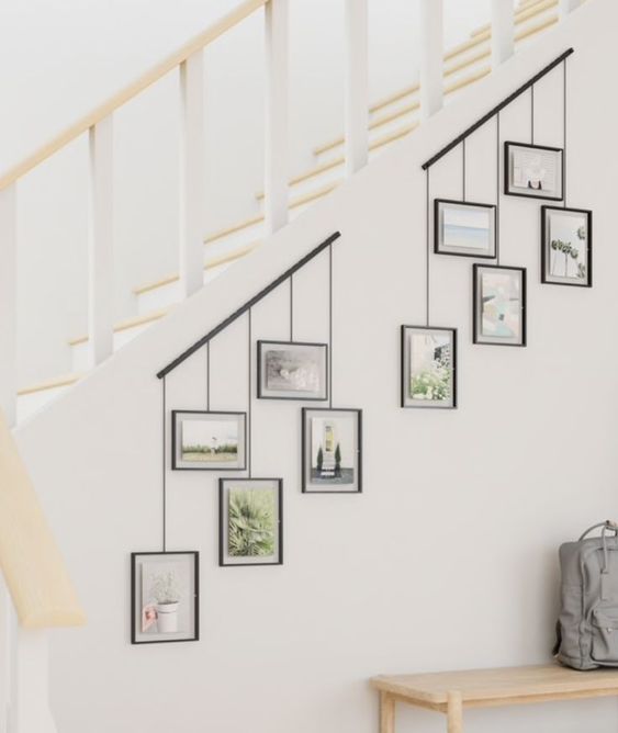 two photo rails attached to the staircase and photos hanging on them will let you comfortably show off your pics