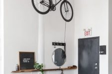 a Scandinavian space with a bike holder attached to the ceiling allows to store it in a creative and comfortable way and make it part of decor