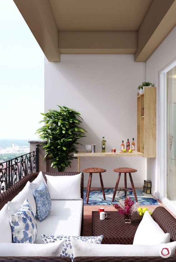 a bold balcony with dark wicker furniture, a small Murphy bar and stools plus a statement plant in the corner