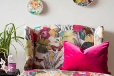 a bold floral loveseat, a gallery wlal with floral embroidery are cool and bright additions to a living room