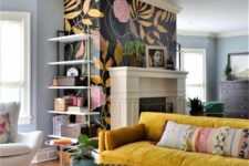 a bright living room with a black floral accent wall and a fireplace, a mustard sofa, chairs and coffee tables