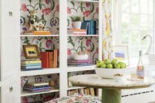 a catchy nook with a built-in bookcase and floral backing, a vintage round table, floral poufs and floral curtains is vivacious