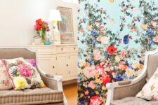 a catchy vintage space with a blue floral accet wall, taupe furniture and floral pillows and some vintage decor
