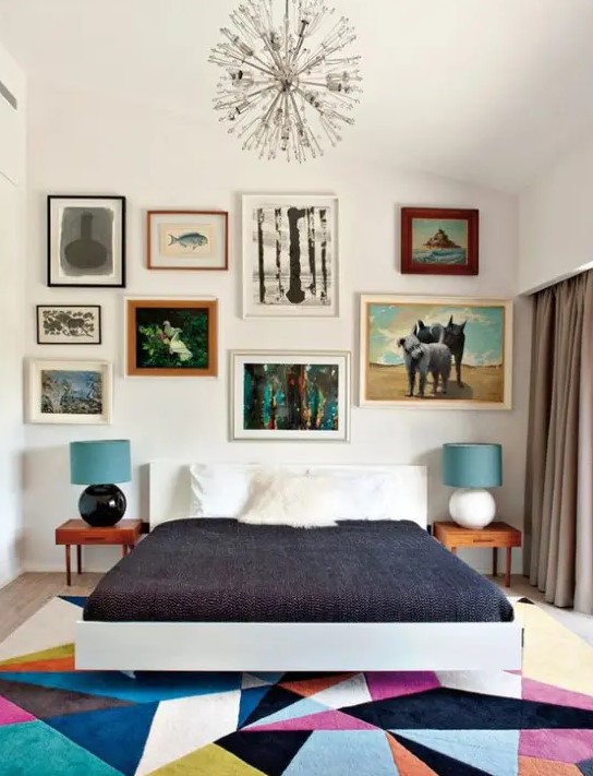 a colorful mid-century modern bedroom with a bright geometric rug, a bed, laconic nightstands and an eclectic gallery wall