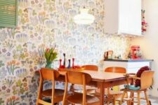 a colorful modern kitchen and dining zone accented with colorful floral wallpaper and with bright accessories for fun