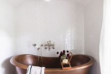 a copper bathtub in the niche with a striped black and white ceiling over it is amazing and it looks very chic