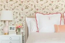 a cozy vintage-inspired bedroom with a floral wallpaper wall, polka dot bedding, vintage-inspired furniture and a blush lamp