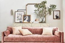 a light-filled living room with a dusty pink sofa, neutral pillows, a gallery wall on credena, a geo print Moroccan rug