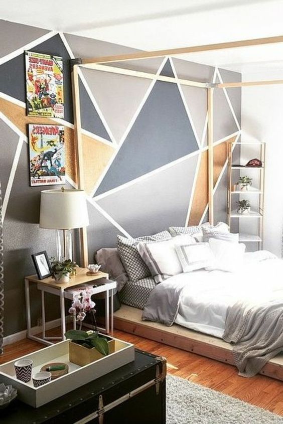 a modern bedroom with a geometric wall mural, a wooden canopy bed, neutral bedding, mismatching nightstands and a black chest
