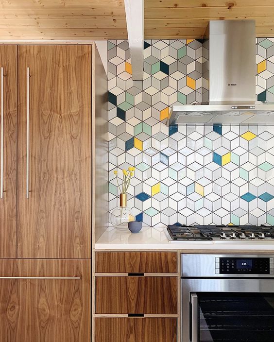 a modern stained kitchen with white countertops, a bright geo tile backsplash and stainless steel appliances
