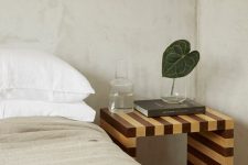 a neutral bedroom with an eye-catchy striped nightstand of wood is a gorgeous way to add print to the space