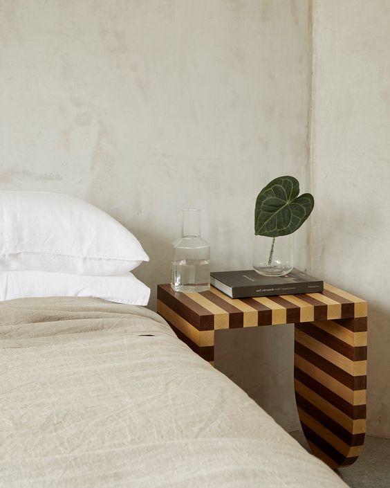 a neutral bedroom with an eye catchy striped nightstand of wood is a gorgeous way to add print to the space