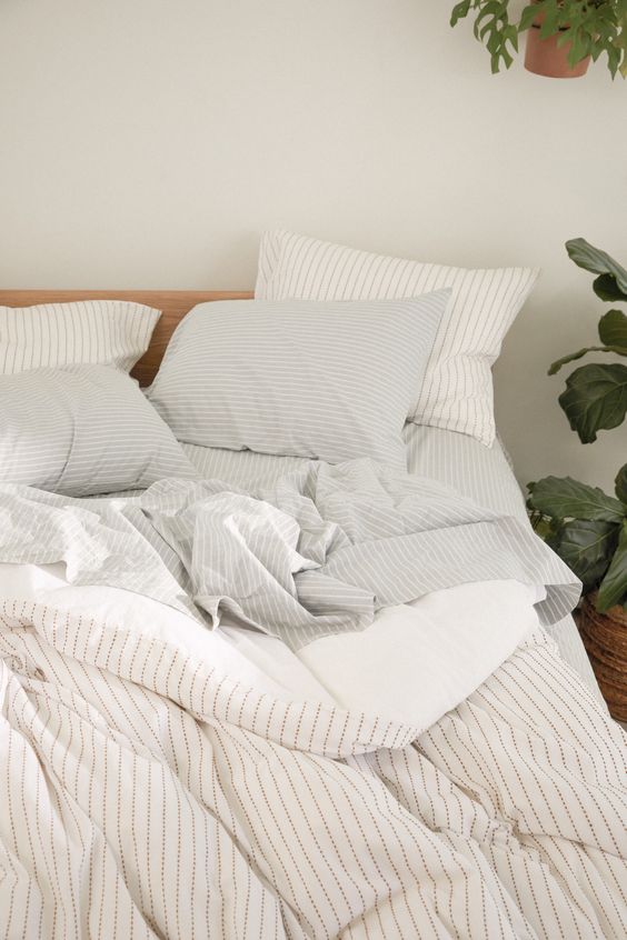 a neutral striped bedding in tan, white and grey, with various parts with various prints will add interest to your bed
