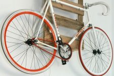 a pallet shelf holding a bike is a cool idea for a rustic or industrial space and it can be placed anywhere
