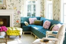 a pretty and chic living room with bright floral wallpaper, a navy sectional, a striped chair, a non-working fireplace, a bold neon yellow ottoman