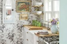 a vintage kitchen with white shaker cabinets, a black and white floral wallpaper wall, butcherblock countertops, open shelves and a subway tile backsplash