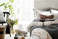 a welcoming and airy spring bedroom in neutrals, with potted greenery and plants, a basket, some floral bedding