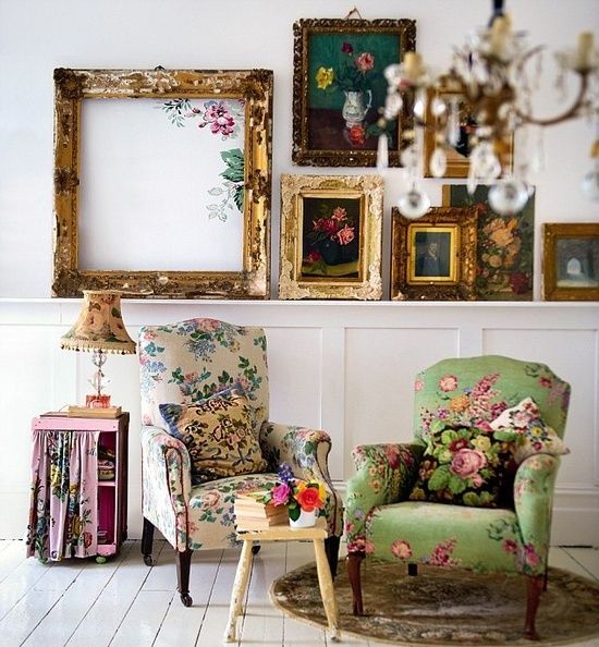 a white space with vintage furniture, floral chairs, a gallery wall with sophisticated frames and floral artwork, a side table with floral fabric