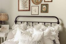 a beautiful and cozy vintage bedroom in neutrals, with a metal bed, a chic gallery wall, printed bedding and white nightstands