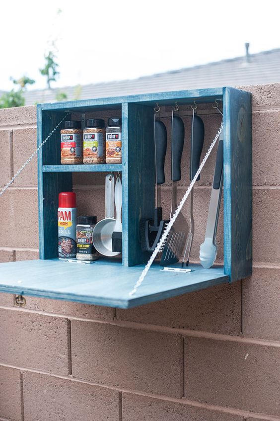 a blue storage box with a folding table will be a nice addition to your outdoor BBQ nook