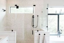 a chic neutral bathroom with grey hex tiles on the floor, faux pebbles in the shower space and planked pony walls and a large window