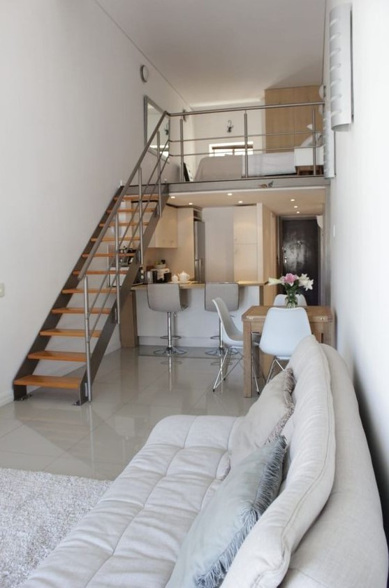 a contemporary home with a restraint color scheme, with a loft sleeping space and a dining-kitchen-living room below