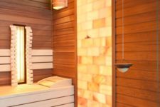 a cool steam room clad with wood and with a mosaic tile part, with some built-in lights is bold and cozy