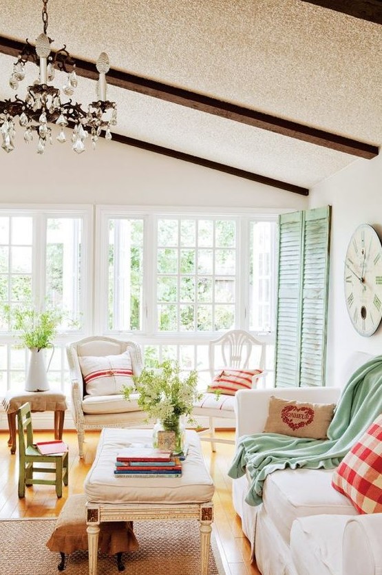 غرف معيشة كلاسيكية A-cottage-Provence-with-green-shutters-neutral-furniture-plaid-and-green-textiles-a-crystal-chandelier-and-a-jute-rug