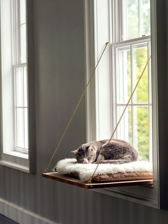 a folding cat bed on chains with a cozy and soft pillow and faux fur will let your cat look outside
