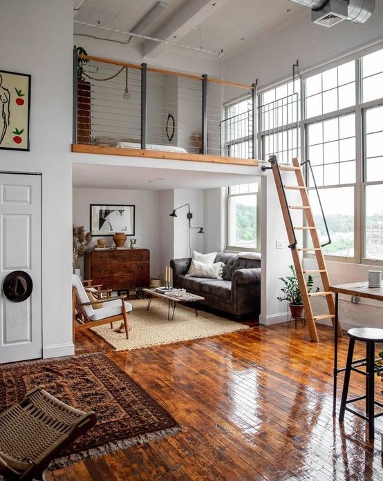 a mid-century modern home with a living and eating space below and a loft sleeping space with a wooden ladder is super cool