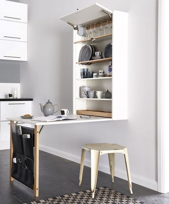 a minimalist wall-mounted dining table with a large storage unit and a leather pocket for smaller stuff
