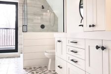 a neutral farmhouse bathroom with mosaic tiles, planked walls and cabinets, a shower space with a half wall