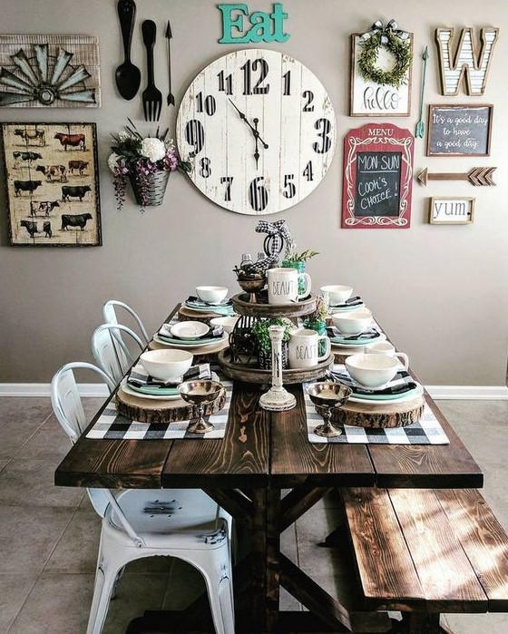 a neutral farmhouse dining area spruced up with a bright gallery wall, with a stained table and bench plus white metal chairs