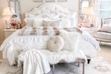a neutral vintage bedroom with a chic gallery wall, mirrors, refined vintage furniture and faux fur and pillows