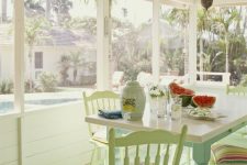 a pretty pastel cottage sunroom with pastel furniture, colorful textiles, a vintage chandelier and much sunshine is lovely